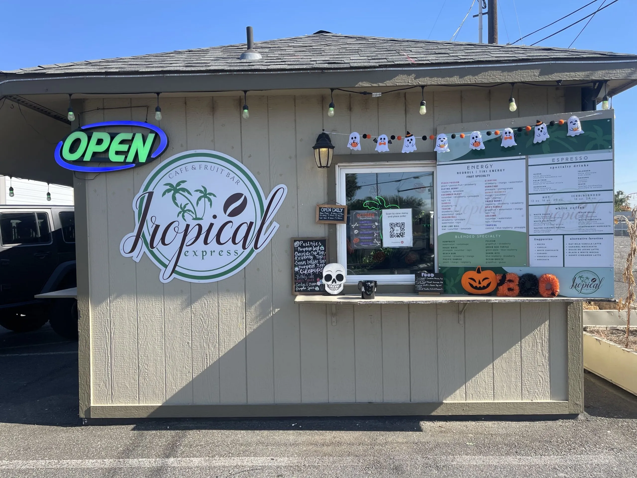 The Tropical Express Othello drive-thru stand with menu boards, an OPEN sign, and the palm-tree logo